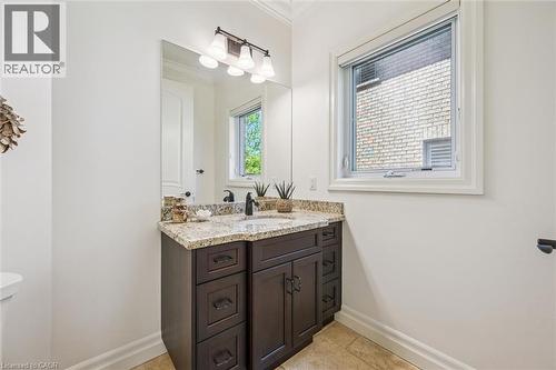 Powder Room vanity featuring a granite countertop, undermount sink, and matte black faucet - 828 Copper Ridge Drive, Waterloo, ON - Indoor Photo Showing Bathroom