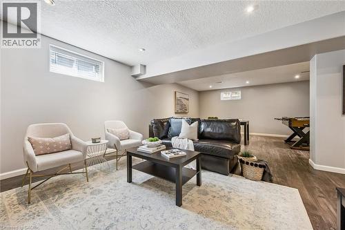 Spacious lower-level living area featuring recessed lighting, wood-finish flooring, and light-toned wall paint - 828 Copper Ridge Drive, Waterloo, ON - Indoor