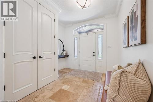 Entryway featuring stone tile flooring, white arched panel doors, crown molding, a transom window, and sidelight windows. - 828 Copper Ridge Drive, Waterloo, ON - Indoor Photo Showing Other Room