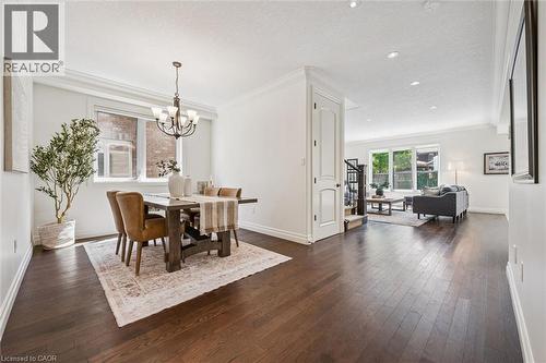 Open-concept living space featuring rich wood-finish flooring, recessed lighting, and crown molding. - 828 Copper Ridge Drive, Waterloo, ON - Indoor Photo Showing Dining Room