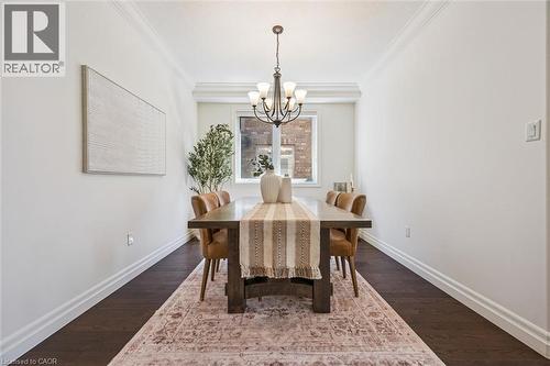 Dining area featuring dark wood-finish flooring, white baseboards, and crown molding. - 828 Copper Ridge Drive, Waterloo, ON - Indoor Photo Showing Dining Room