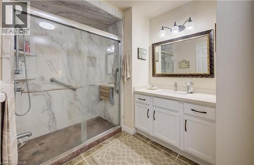 Glass-enclosed shower with a marble-effect surround and grab bars - 16 Steed Court, Brantford, ON 