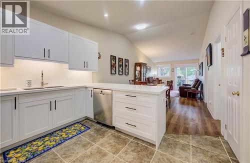 Kitchen featuring white cabinetry, stainless steel dishwasher, undermount sink, and recessed lighting - 16 Steed Court, Brantford, ON 