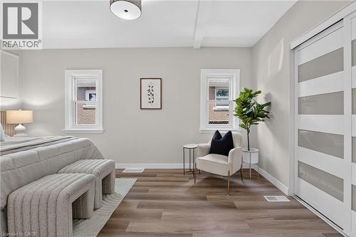 Wood-finish flooring with white trim, two windows, and a ceiling-mounted light fixture - 43 E Brucedale Avenue E, Hamilton, ON 