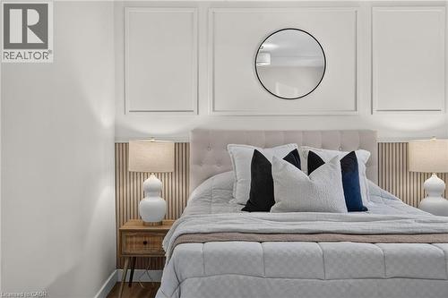 Upholstered tufted headboard against a wood-finish slatted accent wall - 43 E Brucedale Avenue E, Hamilton, ON 
