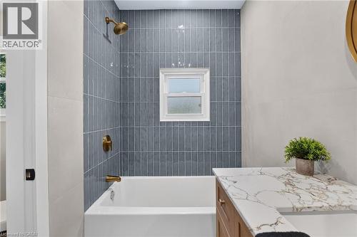 Tub and shower combination with vertical tile surround and brass fixtures - 43 E Brucedale Avenue E, Hamilton, ON 