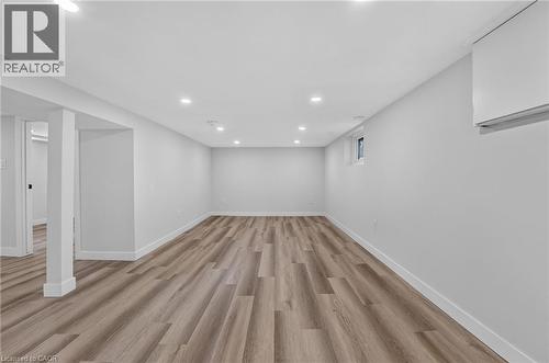Spacious room featuring wood-finish flooring, recessed lighting, and a white interior paint finish - 43 E Brucedale Avenue E, Hamilton, ON 