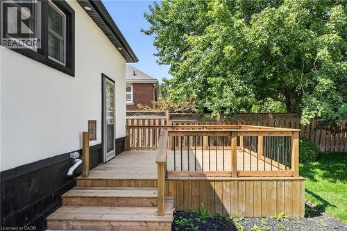 Wood deck with black metal balusters, wood steps, and wood privacy fencing - 43 E Brucedale Avenue E, Hamilton, ON 