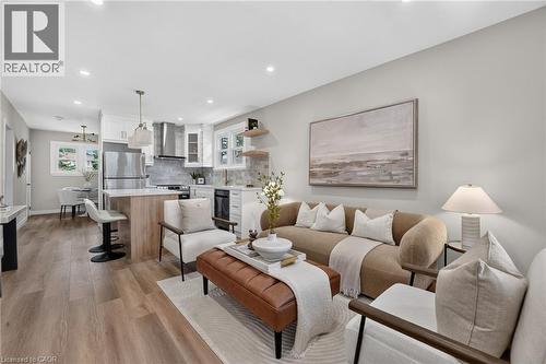 Open-concept living space featuring wood-finish flooring, recessed lighting, and a kitchen island with seating - 43 E Brucedale Avenue E, Hamilton, ON 