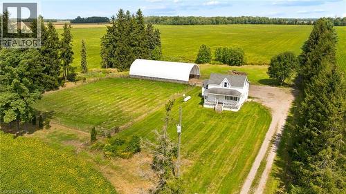 White residence with covered porch, gravel driveway, and detached Quonset hut - 5480 Line 42 Line, Mitchell, ON 