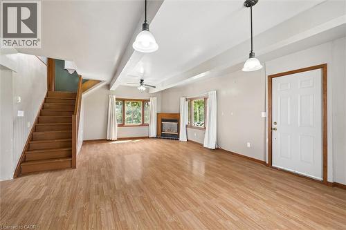 Wood-finish flooring throughout, with a built-in fireplace, exposed ceiling beams, and a ceiling fan - 5480 Line 42 Line, Mitchell, ON 