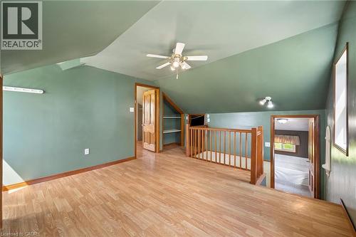 Sloped ceilings with a ceiling fan, wood-finish flooring, wood railing, and built-in shelving - 5480 Line 42 Line, Mitchell, ON 