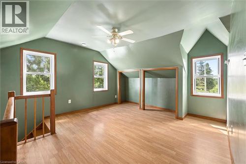 Spacious primary bedroom suite featuring vaulted ceilings with ceiling fan, wood-finish flooring throughout, and multiple windows with wooden frames flooding the space with natural light - 5480 Line 42 Line, Mitchell, ON 