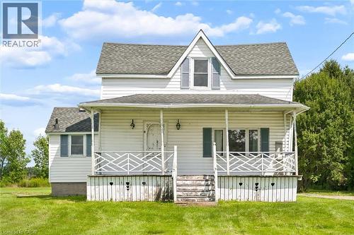 Two-story residence featuring white siding, a full-width front porch with decorative railing, and a gabled roofline - 5480 Line 42 Line, Mitchell, ON 