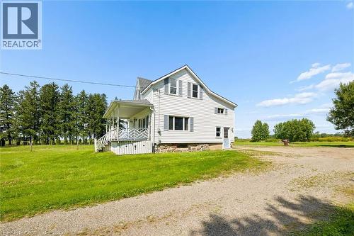 White-sided exterior with a covered front porch featuring decorative railings - 5480 Line 42 Line, Mitchell, ON 