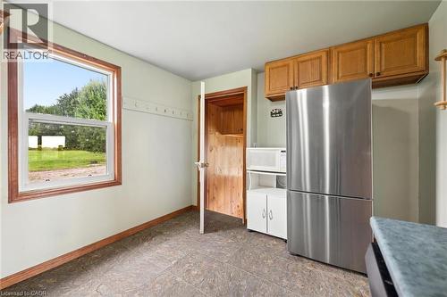 Stainless steel refrigerator, wood-finish cabinetry, and a window with wood-finish trim - 5480 Line 42 Line, Mitchell, ON 