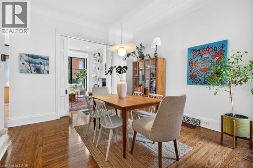 Hardwood flooring with a parquet pattern, white walls, and a recessed doorway - 16 Bruce Street, Hamilton, ON 