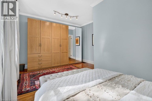 Built-in wardrobe with wood-finish cabinetry and integrated full-length mirrored panels - 16 Bruce Street, Hamilton, ON 