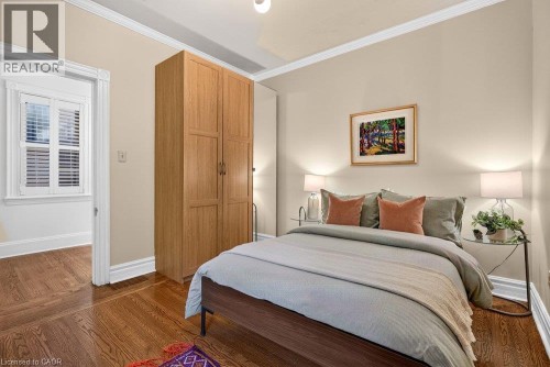 Hardwood flooring, crown molding, a built-in wood-finish wardrobe, and white window shutters - 16 Bruce Street, Hamilton, ON 