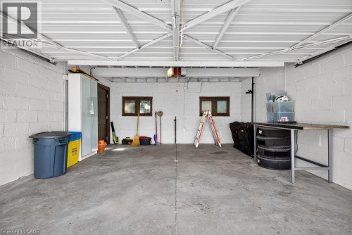 Concrete flooring, painted cinder block walls, exposed metal ceiling joists, and a built-in workbench - 16 Bruce Street, Hamilton, ON 