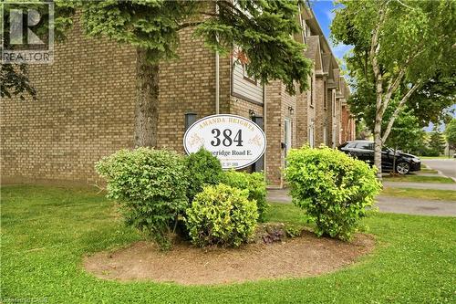Brick exterior with pitched rooflines and adjacent parking area - 384 Limeridge Road E Unit# 16, Hamilton, ON 