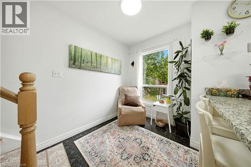 Hardwood-finish staircase with turned newel post, large window, dark tile flooring, and light-toned walls - 384 Limeridge Road E Unit# 16, Hamilton, ON 