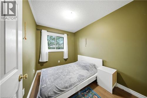 Wood-finish flooring, single window, white trim, and a white interior door with brass hardware - 384 Limeridge Road E Unit# 16, Hamilton, ON 
