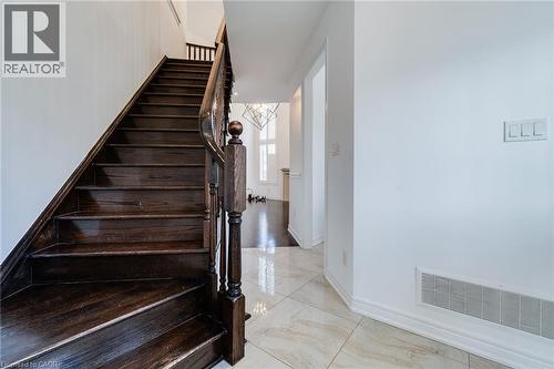 Dark wood staircase with turned newel post, balusters, and handrail - 2 Hawstone Road, Vellore, ON 