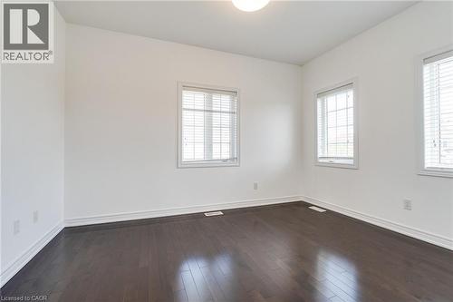 Rich wood-finish flooring, multiple windows with blinds, and a flush mount ceiling light - 2 Hawstone Road, Vellore, ON 