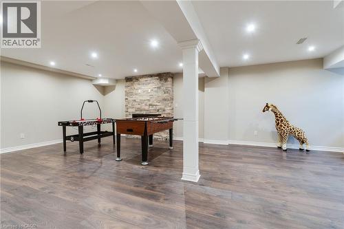 Spacious room featuring wood-finish flooring, recessed lighting, and a stone-clad fireplace - 2 Hawstone Road, Vellore, ON 