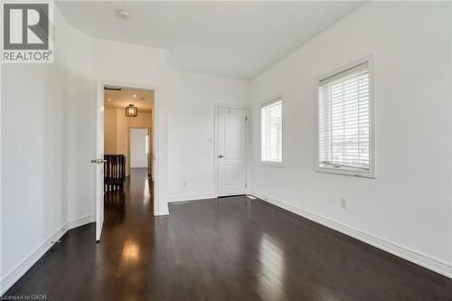 Dark wood-finish flooring, white walls, two windows with horizontal blinds, and white trim - 2 Hawstone Road, Vellore, ON 