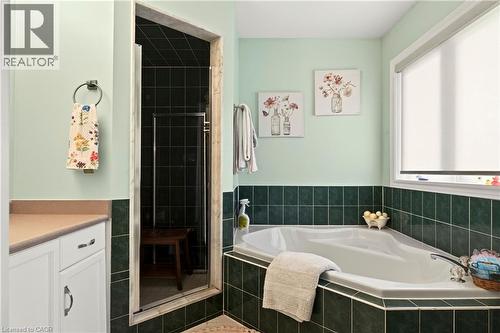 Corner soaking tub with dark green tile surround - 31 Grindstone Way, Hamilton, ON 
