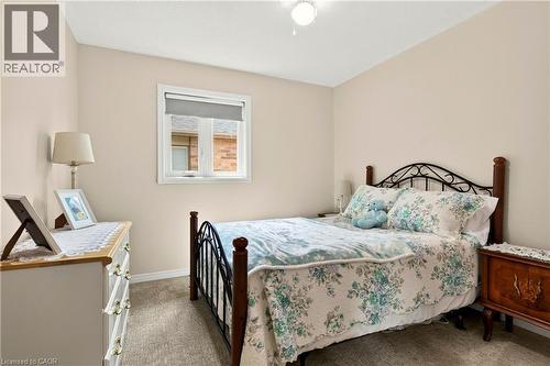 Carpeted flooring, neutral wall tones, and a single window with a roller shade - 31 Grindstone Way, Hamilton, ON 