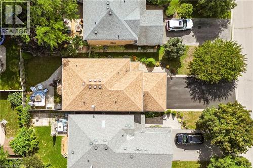 Property featuring a multi-gabled roof, rear patio with paved path, and a fenced backyard - 31 Grindstone Way, Hamilton, ON 