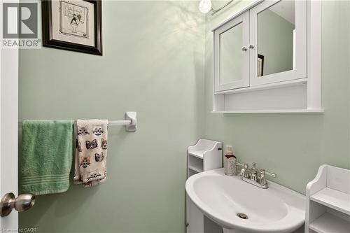 Pedestal sink with chrome-finish faucet, medicine cabinet with mirrored doors, and overhead lighting - 31 Grindstone Way, Hamilton, ON 