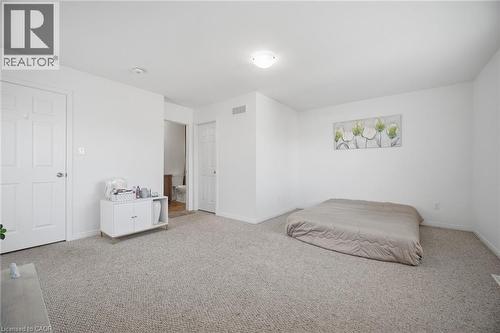 Carpeted room with white walls, white paneled doors, and an overhead flush-mount light fixture - 135 Hardcastle Drive Unit# 85, Cambridge, ON 