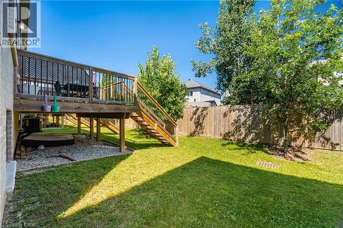 Expansive backyard featuring a wood deck with lattice railing, a wood privacy fence, and mature trees - 135 Hardcastle Drive Unit# 85, Cambridge, ON 