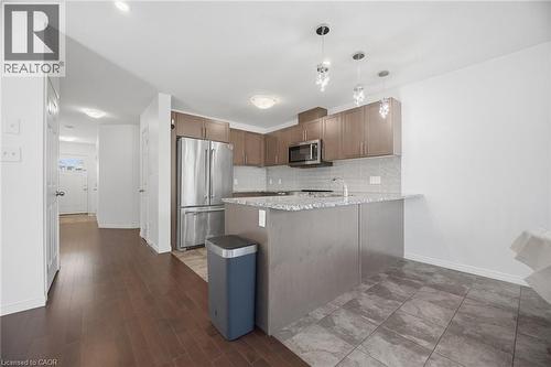 Modern kitchen featuring stainless steel appliances, stone countertops, a tiled backsplash, and pendant lighting - 135 Hardcastle Drive Unit# 85, Cambridge, ON 