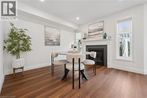 Wood-finish flooring, recessed lighting, and a prominent fireplace with a white mantel and dark surround - 2294 Seton Crescent, Burlington, ON 