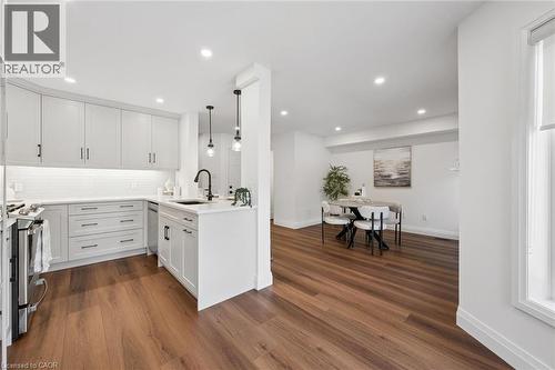Kitchen featuring light-toned cabinetry, a subway tile backsplash, and a black sink - 2294 Seton Crescent, Burlington, ON 