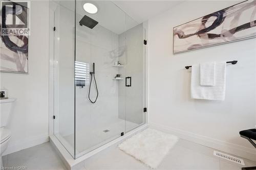 Corner glass-enclosed shower with a matte black rain shower head and handheld spray - 2294 Seton Crescent, Burlington, ON 