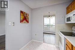 Kitchen with tile flooring, wood-finish cabinetry, and white appliance suite - 