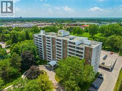 High-rise building with extensive surrounding greenery, dedicated surface parking, and a covered entryway - 
