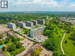Expansive green spaces and mature trees surround multiple residential buildings, with paved walking paths throughout the grounds - 