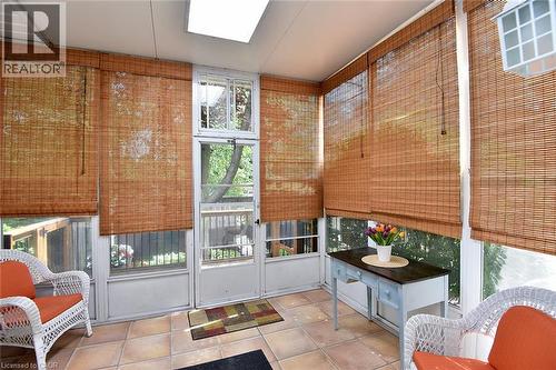 Sunroom featuring tiled flooring, multiple windows, and a skylight - 936 Boothman Avenue, Burlington, ON 