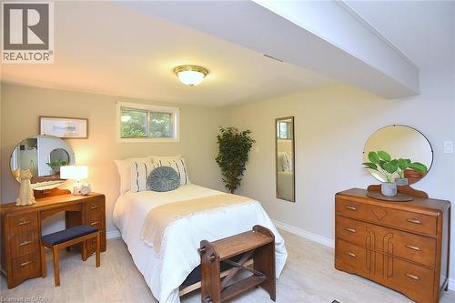 Wall-mounted window, flush-mount ceiling light fixture, exposed ceiling beam, and wood-finish flooring - 936 Boothman Avenue, Burlington, ON 