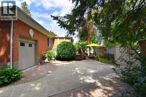 Brick exterior featuring an integrated garage, concrete driveway, and paver stone accents - 936 Boothman Avenue, Burlington, ON 