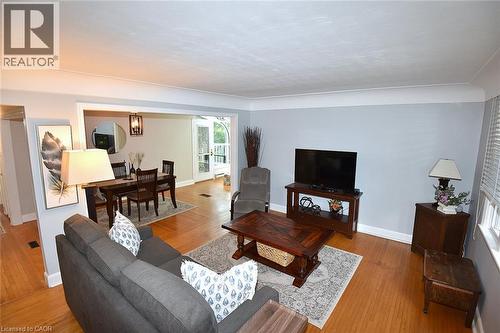 Hardwood-style flooring throughout, cased opening to an adjacent room, white trim details, and window blinds - 936 Boothman Avenue, Burlington, ON 