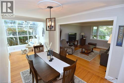 Wood-finish flooring throughout, recessed lighting, crown molding, open archway, and a sunroom with expansive windows - 936 Boothman Avenue, Burlington, ON 