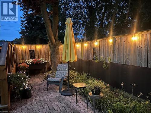 Paver patio with a wood privacy fence, string lighting, and integrated plantings - 936 Boothman Avenue, Burlington, ON 